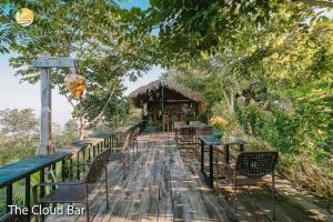 a wooden deck with tables and chairs and a building at TV Palm Ecolodge Ha Giang in Ha Giang +68 photos