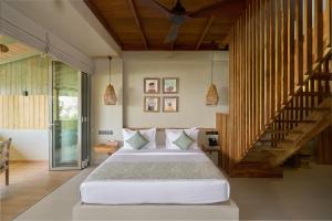a bedroom with a large bed and a staircase at Stay Ceylon - Weligama in Weligama