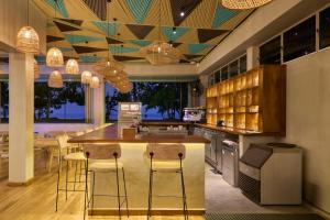 a kitchen with a island with bar stools at Stay Ceylon - Weligama in Weligama +29 photos