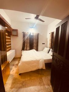 a bedroom with a bed and a ceiling fan at Blue mount stay in Gūdalūr