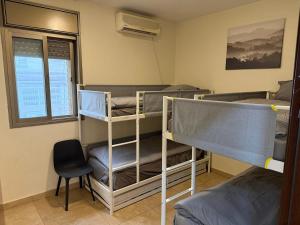 a room with two bunk beds and a chair at Har nof rooftop in Jerusalem