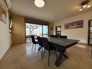 a dining room with a black table and chairs at Har nof rooftop in Jerusalem