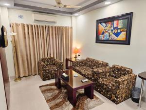a living room with two couches and a coffee table at Royal Hotel Khulna - City Center in Khulna