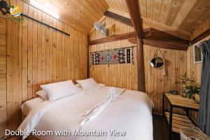 a bedroom with a bed in a room with wooden walls at TV Palm Ecolodge Ha Giang in Ha Giang