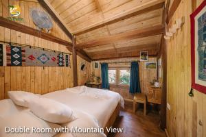 a bedroom with a bed in a room with wooden walls at TV Palm Ecolodge Ha Giang in Ha Giang
