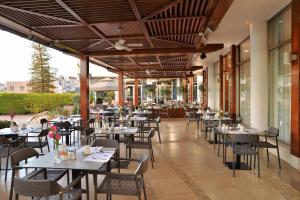 an empty restaurant with tables and chairs at Ajax Hotel in Limassol