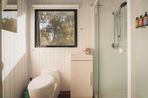 a small bathroom with a toilet and a window at Mirror Reflections by Tiny Away in Tamborine