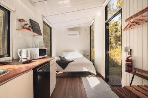 a small bedroom in a tiny house with a bed at Mirror Reflections by Tiny Away in Tamborine +20 photos