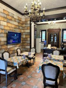 a dining room with tables and chairs and a chandelier at Royal Historical Boutique Hotel in Baku