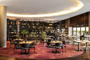 a restaurant with tables and chairs and a bar at Vienna House by Wyndham Andel's Cracow in Krakow