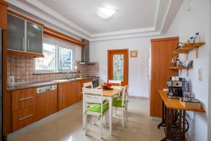 a kitchen with wooden cabinets and a table with chairs at Seascape Village - Spacious 3-Bed Apartment with Private Garden and Parking in Kalithies