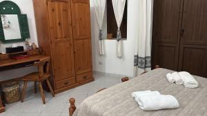 a bedroom with a bed with two towels on it at Domo via Ozieri in Iglesias