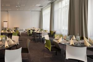 a conference room with tables and chairs and a large window at Sunday Hotel Leipzig in Leipzig