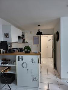 a kitchen with white cabinets and a tile floor at Le Colibri in Fenouillet