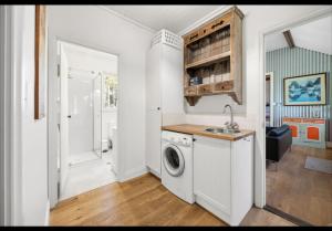 a kitchen with a washing machine and a sink at Amara Creek Retreat in Margaret River Town