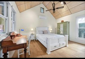 a bedroom with a white bed and a piano at Amara Creek Retreat in Margaret River Town