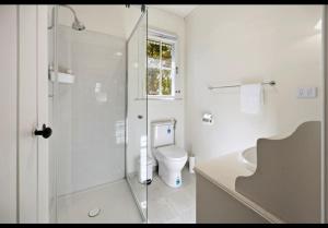 a white bathroom with a shower and a toilet at Amara Creek Retreat in Margaret River Town +8 photos