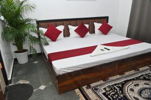 a bed in a room with red and white pillows at pitambara studio apartment with kitchen in Karadoho +13 photos
