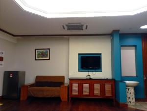 a living room with a couch and a flat screen tv at GLX Private Pool Villa in Port Dickson