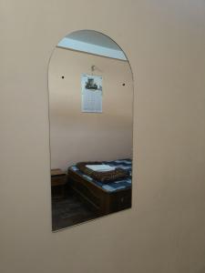 a mirror reflecting a bed in a room at Abhishek Homestay in Dum Duma