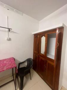 a room with a chair and a table and a cabinet at Ridge Bae Homestay in Varkala