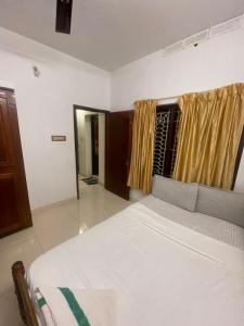 a bedroom with a large white bed in a room at Ridge Bae Homestay in Varkala