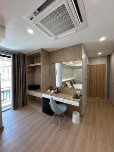 a room with a desk and a bed with a mirror at Whiteinn - ไวท์อินน์ in Nonthaburi