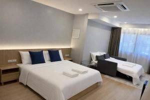 a hotel room with two beds and a window at Whiteinn - ไวท์อินน์ in Nonthaburi