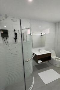 a bathroom with a shower and a sink and a toilet at Whiteinn - ไวท์อินน์ in Nonthaburi