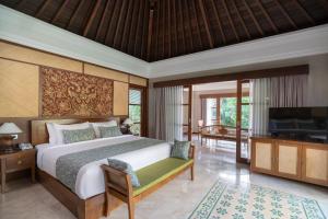 a bedroom with a bed and a flat screen tv at Royal Arkara Villas by Arkamara in Ubud