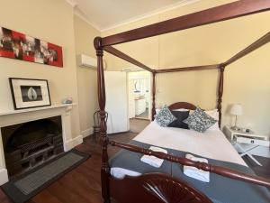 a bedroom with a four poster bed and a fireplace at Imperial Homestead in York