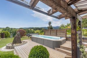 a backyard with a hot tub and a pergola at das "Ferienhaus Eibiswald" Landhaus Refugium im Schilcherland - Sauna und Spa in Eibiswald