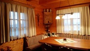 a dining room with a wooden table and windows at Kellerstöckl am Rosenberg in Straden