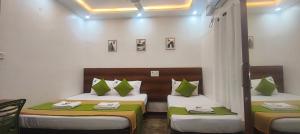 a room with two beds with green and white pillows at Royal Green Residency Chennai Airport in Chennai