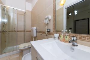 a bathroom with a sink and a toilet and a mirror at Martina B&B in Agropoli