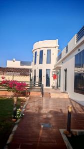 a large white building with pink flowers in front of it at Highness Villa Nizwa in Nizwa
