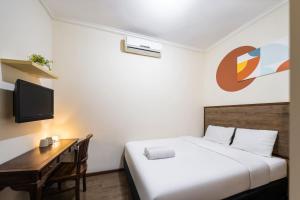 a bedroom with a bed and a desk and a television at Cove Casavanda in Serpong +10 photos