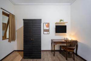 a dining room with a table and a black cabinet at Cove Casavanda in Serpong