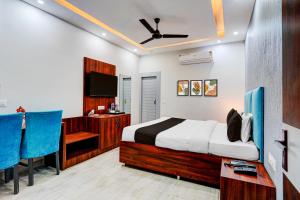 a bedroom with a bed and a desk and a television at Collection O Kotdwar Railway Junction Formerly K Square in Kotdwāra +35 photos