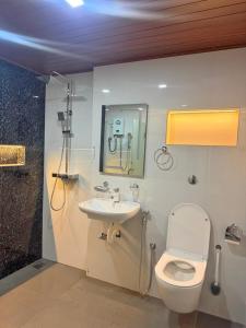 a bathroom with a toilet and a sink and a shower at R&B Guest House in Jaffna