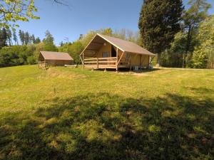a cabin with a roof on a grass field at Glamping Podere Poggiagrilli in San Gervasio