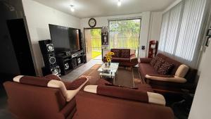 a living room with couches and a flat screen tv at Villa Mariaclaudia in Macas