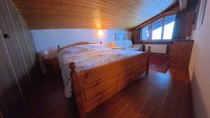 a bedroom with a large wooden bed in a room at Chalet Rezia in Savognin