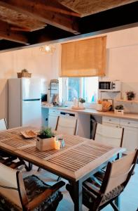 a kitchen with a wooden table with chairs and a kitchen with a refrigerator at La Mata primera línea de playa in Torrevieja
