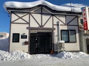 a building with snow in front of it at La Station in Bibai
