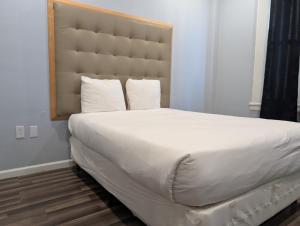 a large white bed with a large headboard in a bedroom at Winsor Hotel in San Francisco