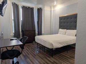 a bedroom with a bed and a desk and a table at Winsor Hotel in San Francisco