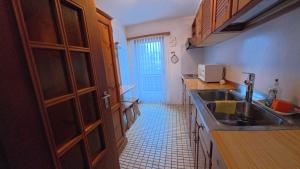 a kitchen with a sink and a tile floor at Chalet Rezia in Savognin +8 photos
