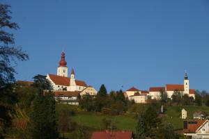 a village on a hill with a church at Kellerstöckl am Rosenberg in Straden