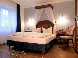 a bedroom with a large bed with a canopy at Historisches Genusshotel Löwen in Schopfheim +29 photos